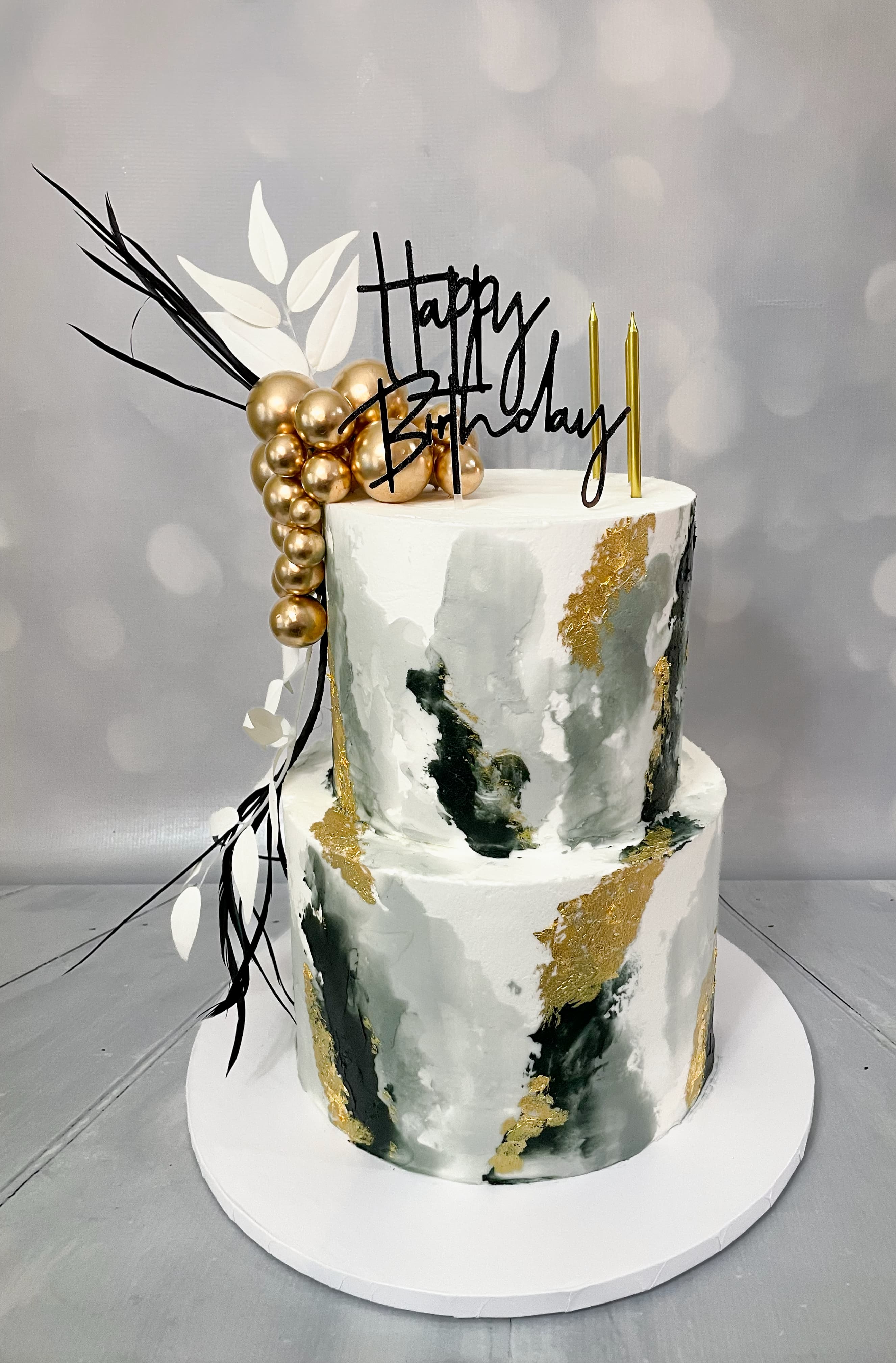 Modern black white and gold two-tier birthday cake with abstract decorations by Sweet Cakes by Kristen
