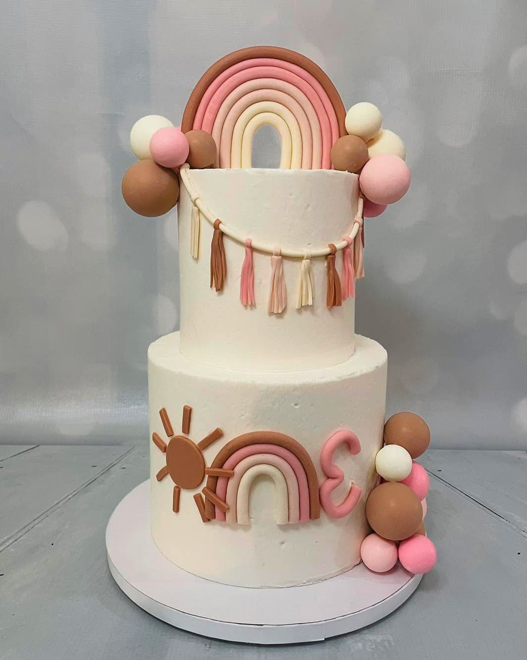 Boho rainbow two-tier birthday cake with pastel rainbow decorations by Sweet Cakes by Kristen