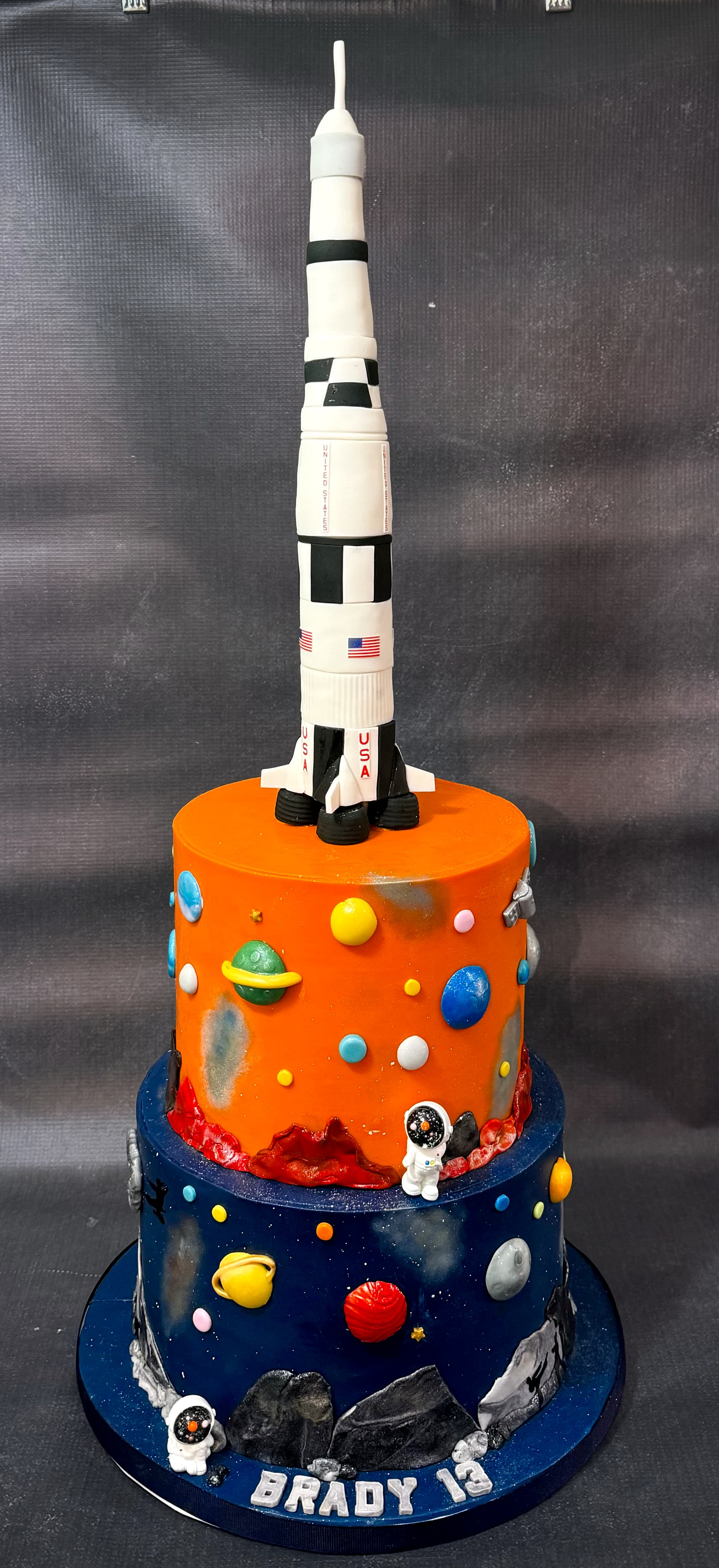 Space themed birthday cake with rocket planets and astronaut decorations by Sweet Cakes by Kristen