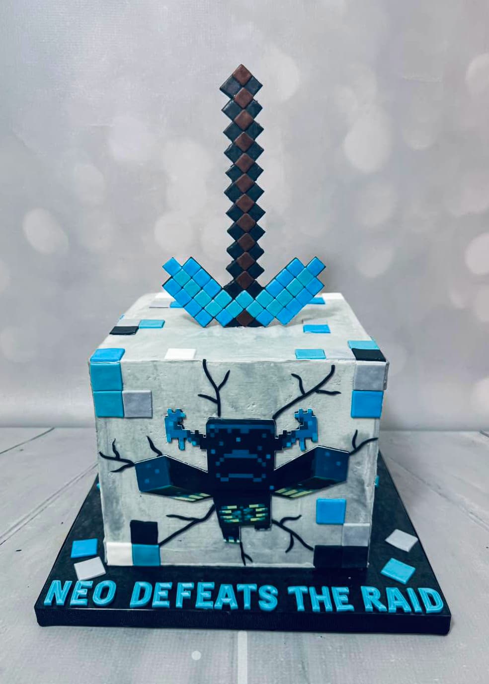Minecraft-themed custom birthday cake with block design and sword topper by Sweet Cakes by Kristen