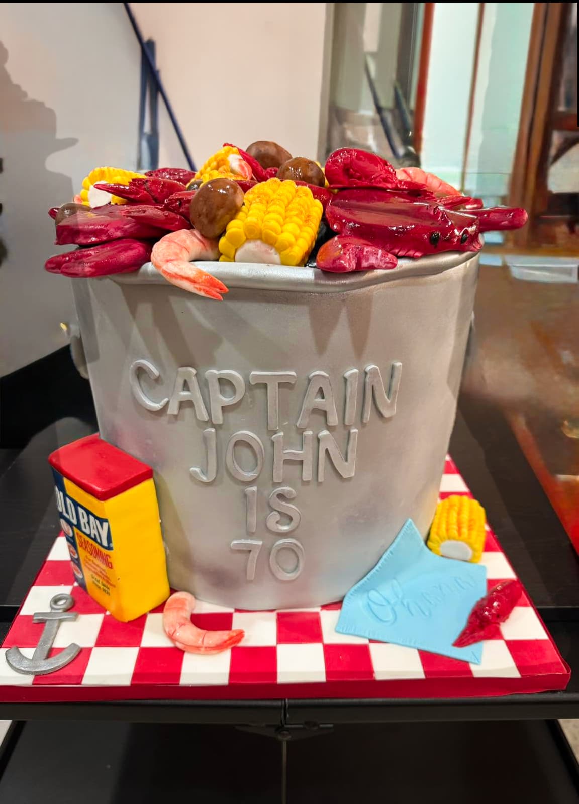 Seafood boil birthday cake sculpted as a pot filled with crawfish shrimp corn and potatoes by Sweet Cakes by Kristen