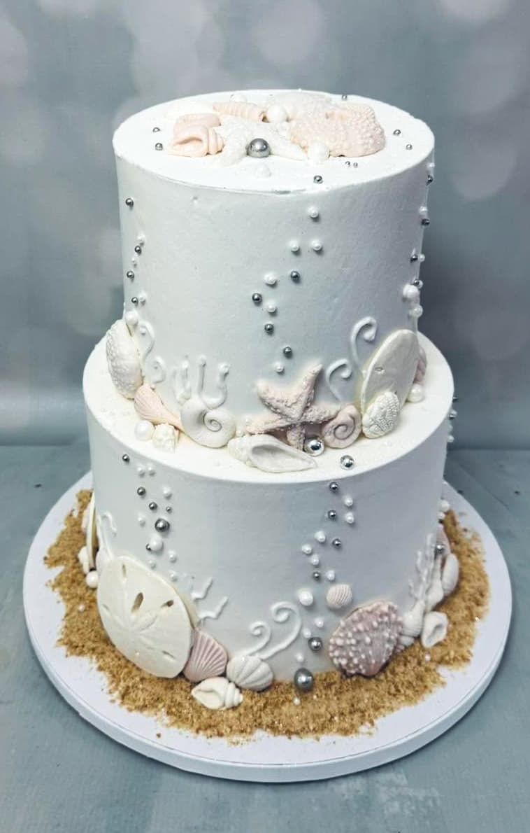 White coastal wedding cake decorated with seashells and pearl details by Sweet Cakes by Kristen