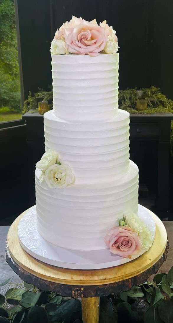 Three-tier white wedding cake with soft pink and ivory roses, made by Sweet Cakes by Kristen